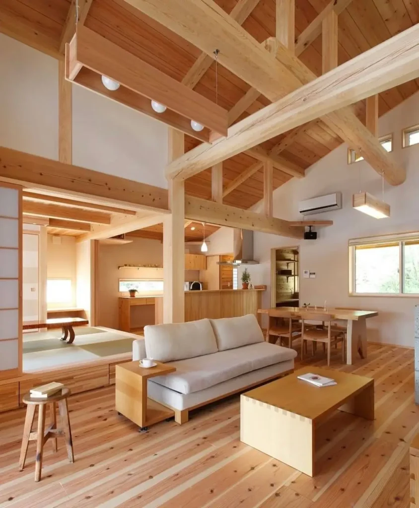 A modern Japanese open-plan living room with vaulted wood ceilings and an adjoining raised tatami area.