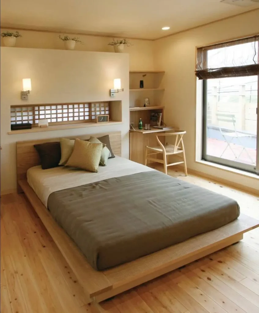A modern Japanese bedroom by Eco Works with a low wooden platform bed and a built-in headboard desk unit.