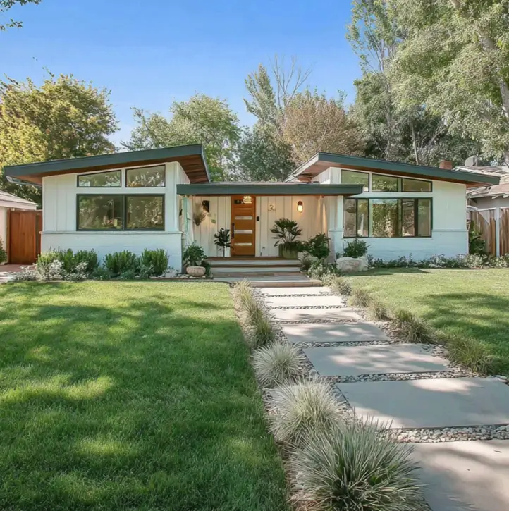 A modern white ranch house with clerestory windows and a wooden front door.