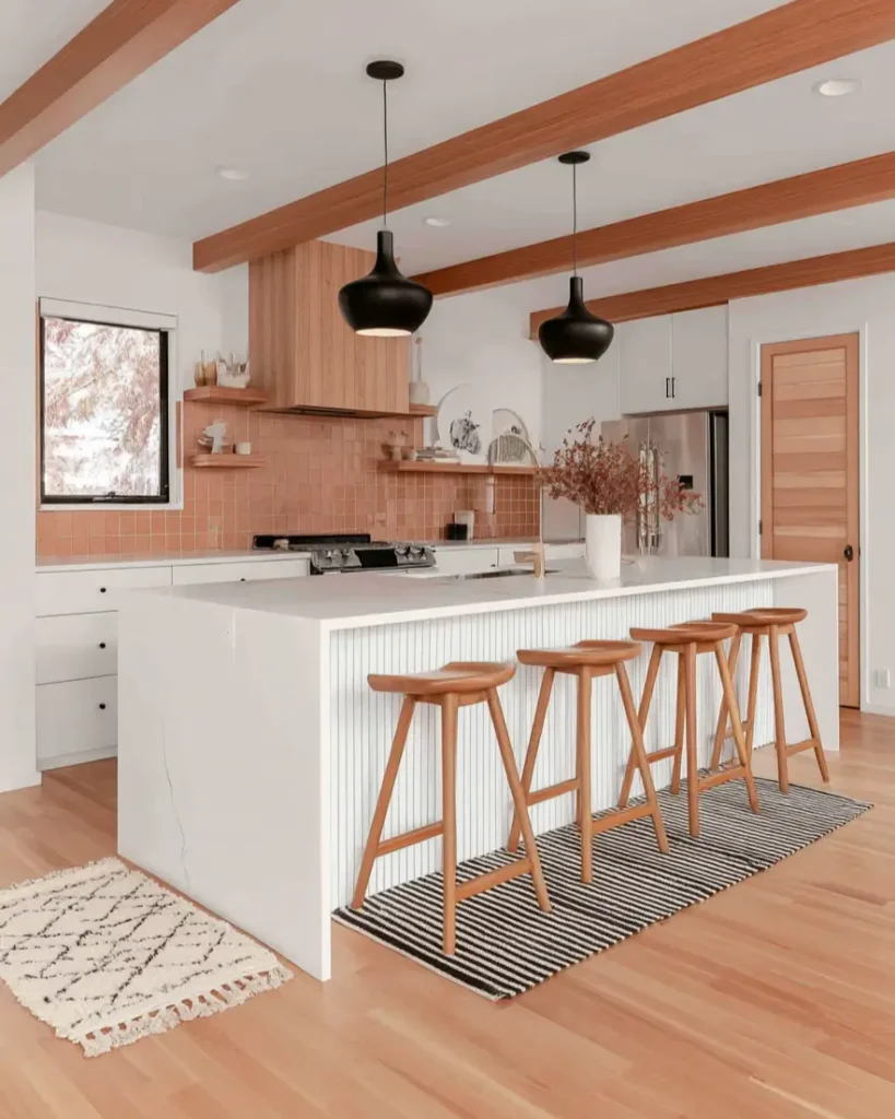 Modern ranch kitchen with wood beams, a white fluted island, and terracotta tile backsplash.