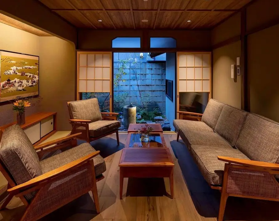 Cozy Japanese living room with wood-framed furniture, a wood ceiling, and a courtyard view.