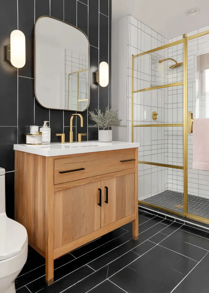 A modern ranch style bathroom with black tile, a wood vanity, and brass fixtures.