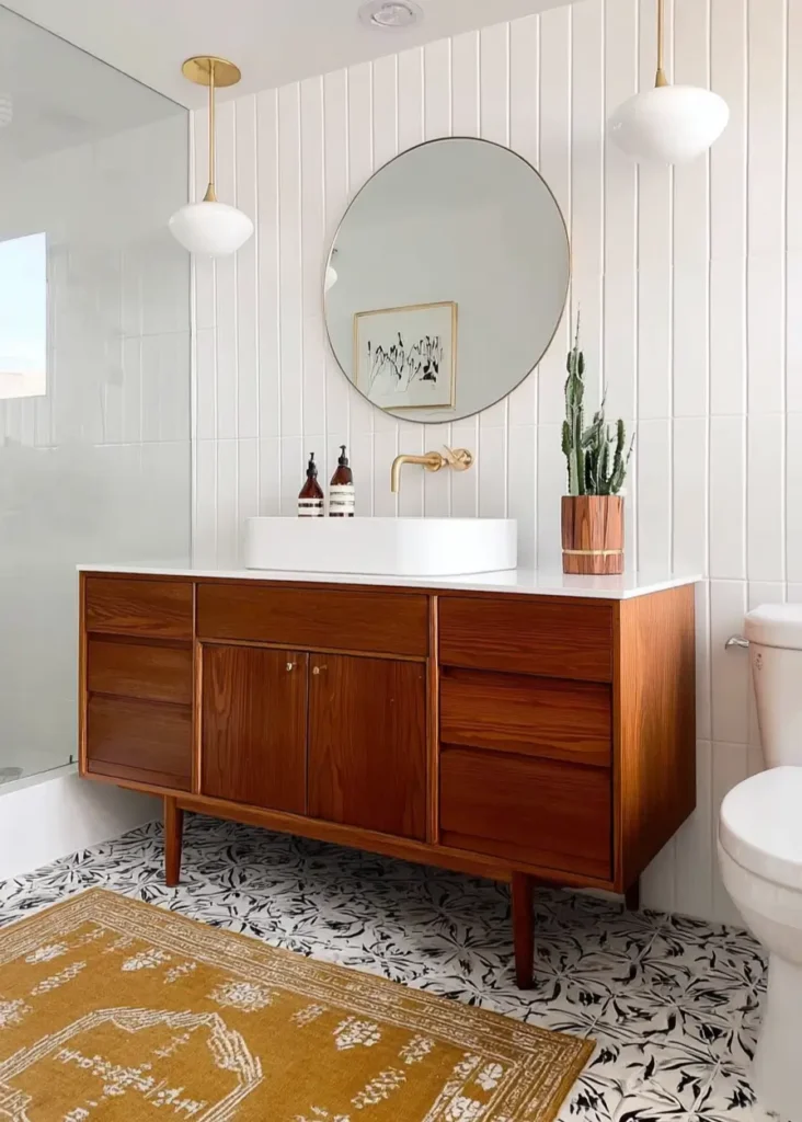 43 Mid Century Modern Small Bathroom Ideas for a Timeless Oasis (2025) 6 Teak vanity with tapered legs and globe pendant lights in a mid century modern small bathroom.