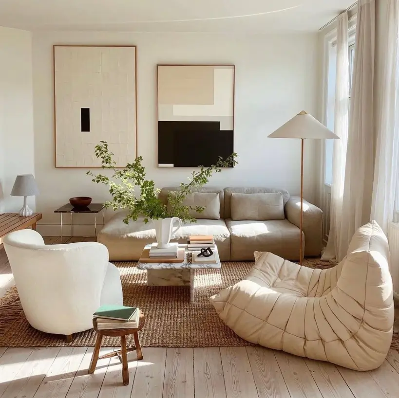 A bright Japandi living room featuring neutral Scandi furniture, a natural jute rug, and minimalist art.