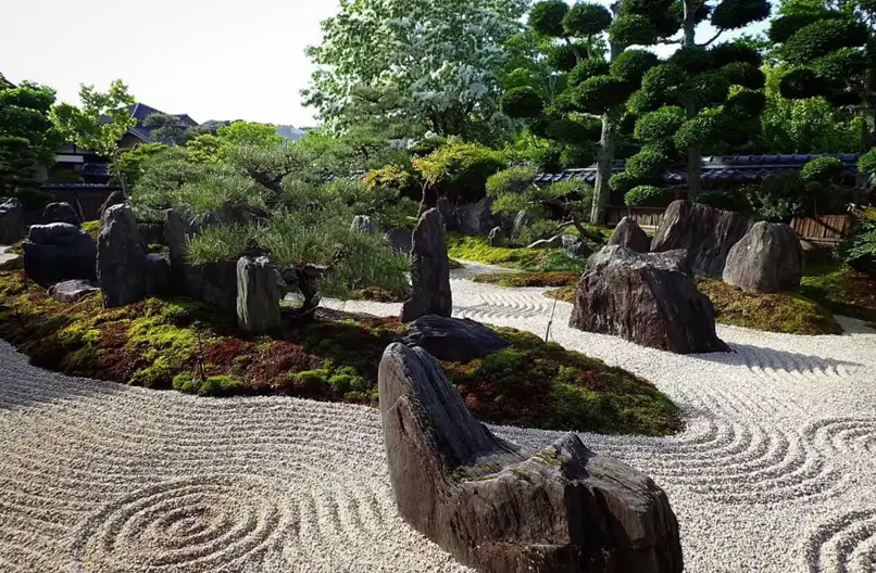 Zen garden design with raked gravel sea and large, mossy stone island formations.