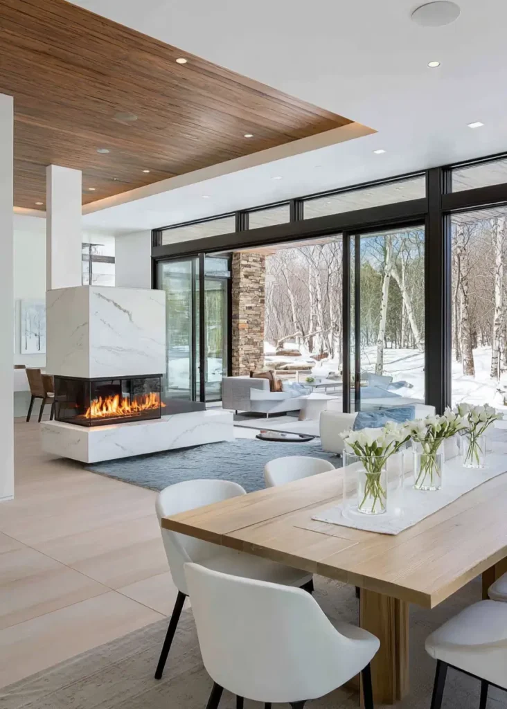 Modern ranch interior design open-concept space with a three-sided fireplace and large glass doors.