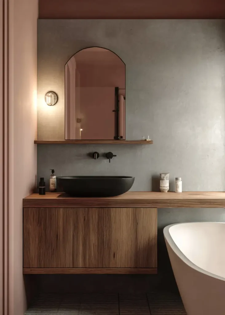 46 Scandinavian Bathroom Design Ideas for a Serene Sanctuary 47 Matte black vessel sink on walnut vanity against a grey concrete wall with an arched mirror.