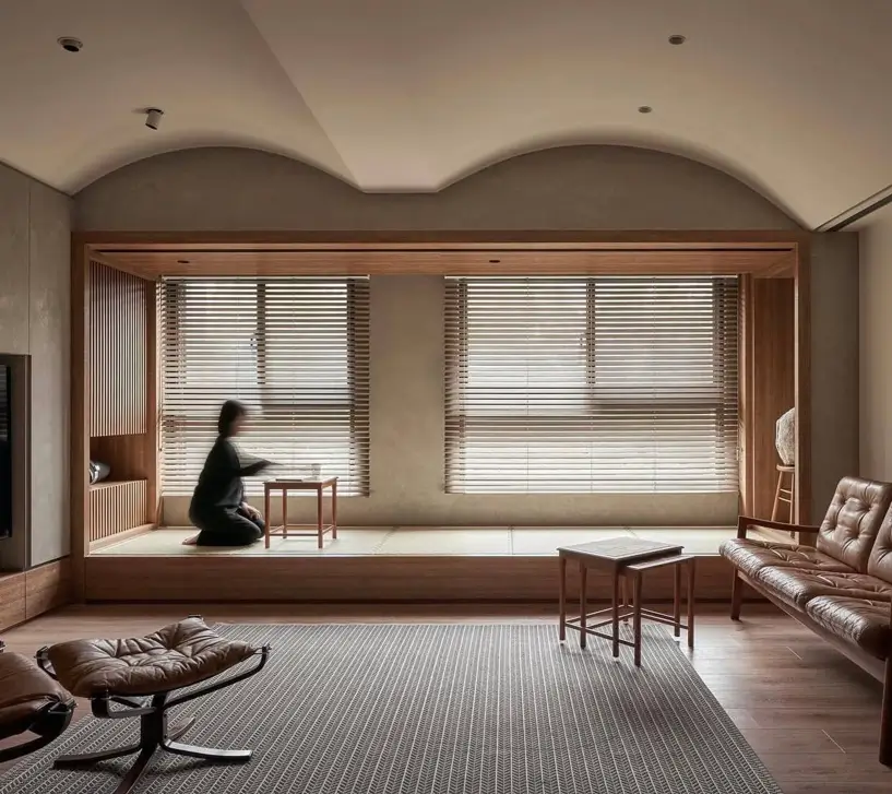 Modern living room with a raised Japanese-style seating platform and leather furniture.