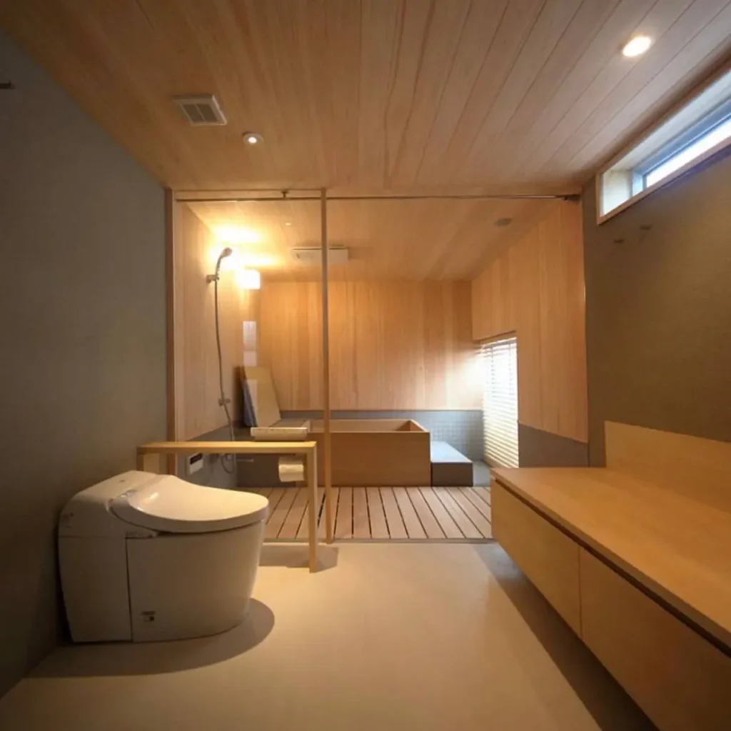 26 Japanese Bathroom Design Ideas for a Serene Home Oasis 9 A Japanese bathroom with a separate glass-enclosed wet room, wooden tub, and modern toilet.