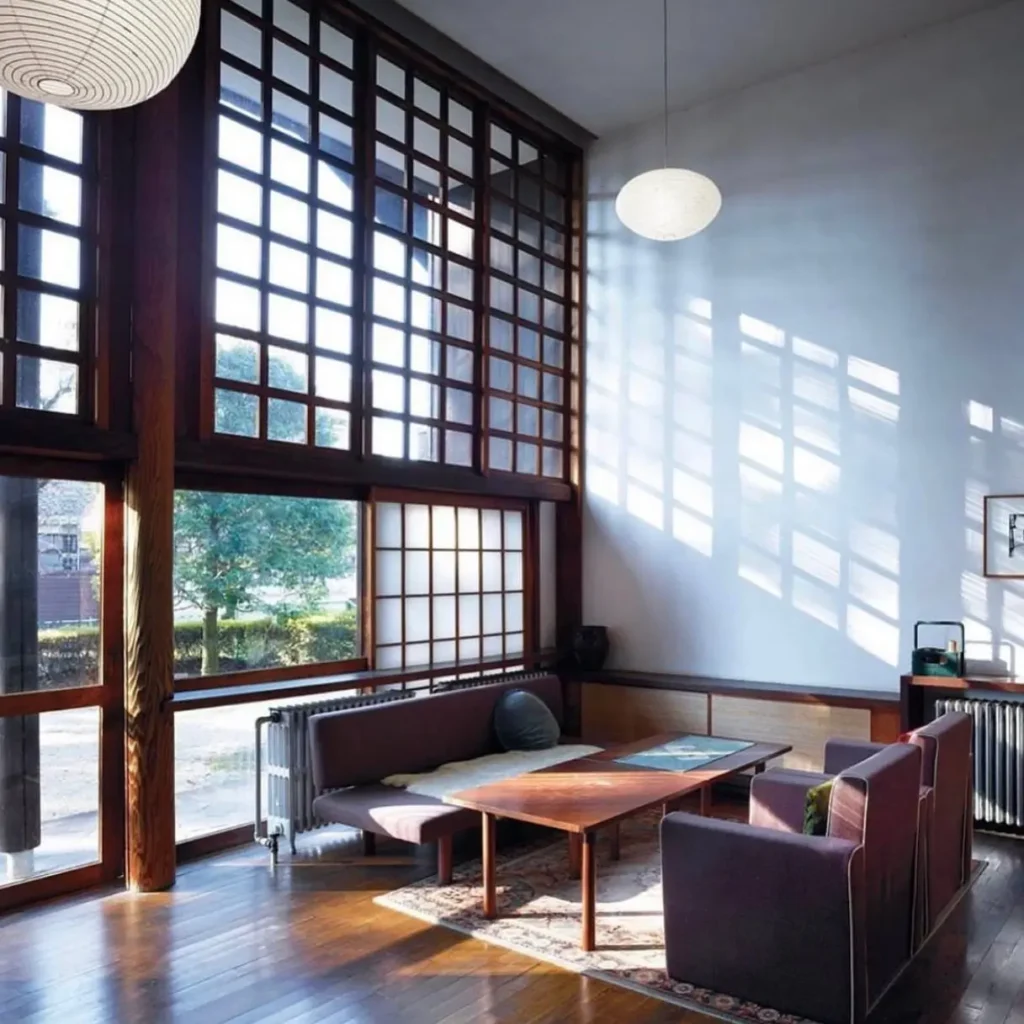 Japanese style living room with a large lattice window casting dramatic grid shadows on the wall.