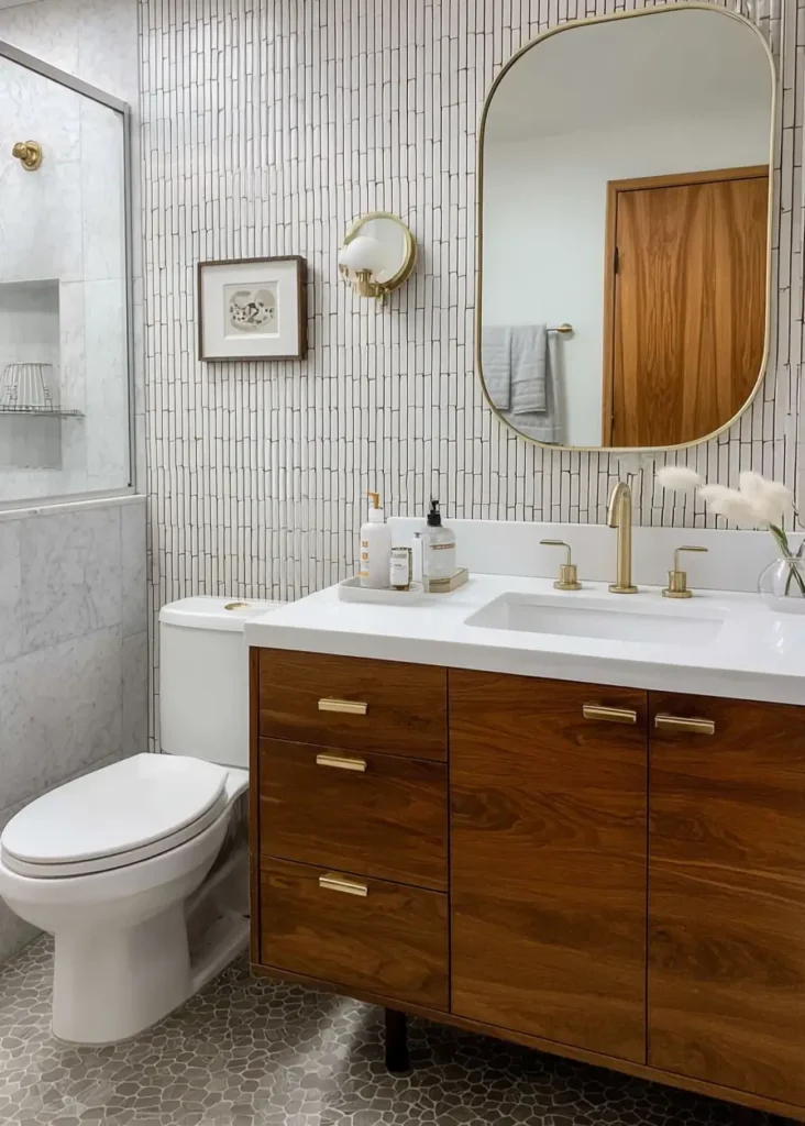 43 Mid Century Modern Small Bathroom Ideas for a Timeless Oasis (2025) 11 Vertical white kit kat tiles with wood vanity and brass mirror in a mid century small bathroom.