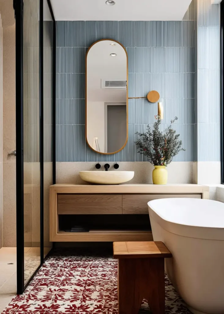46 Scandinavian Bathroom Design Ideas for a Serene Sanctuary 11 Blue vertical kit-kat tiles behind a wood vanity with patterned red and white floor tiles in a modern bathroom.