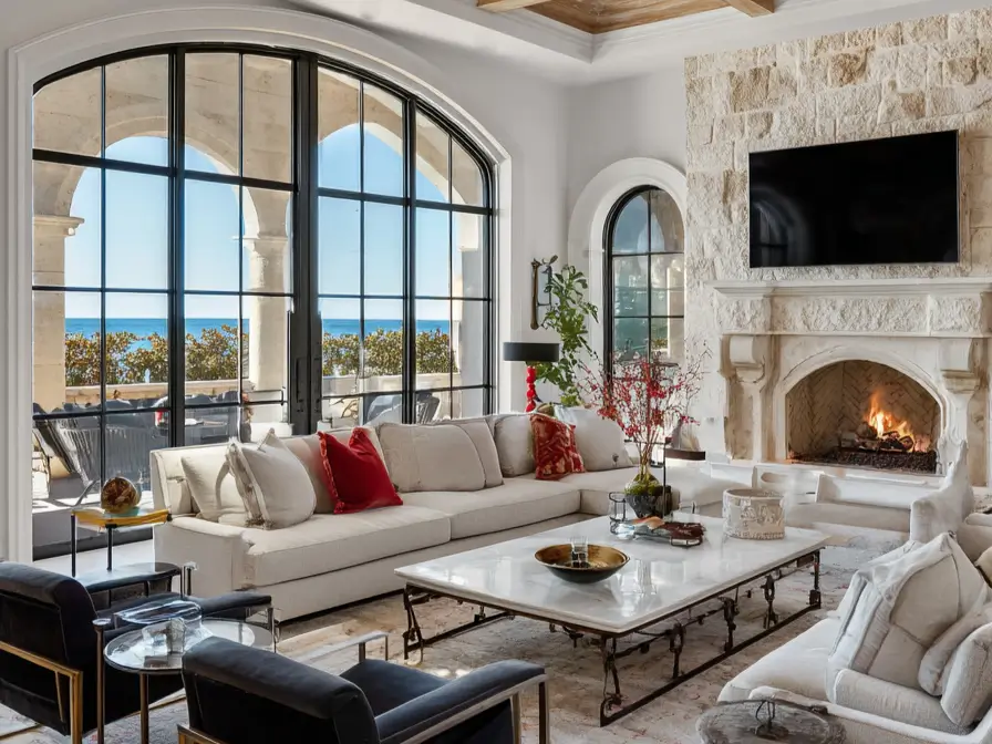 Luxury modern Mediterranean living room with arched windows, ocean view, white sectional, and natural stone fireplace.