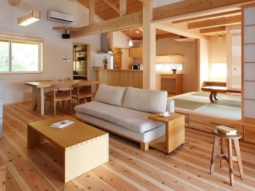 A modern Japanese home interior design idea, with an open-plan living room, light wood floors, and a raised tatami room.