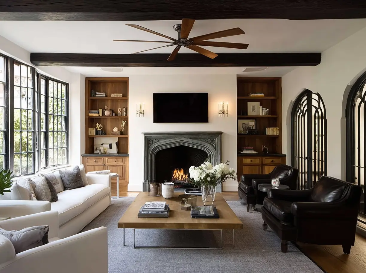 Modern Tudor Interior Design: A Definitive Guide 2 A modern Tudor interior design living room with white walls, dark ceiling beams, and a carved stone fireplace.