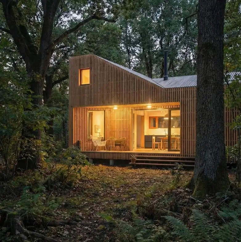 33 Small Scandinavian House Ideas That Prove Less Is More 3 Small Scandinavian house exterior featuring vertical untreated cedar cladding and large glass sliders in a forest setting.