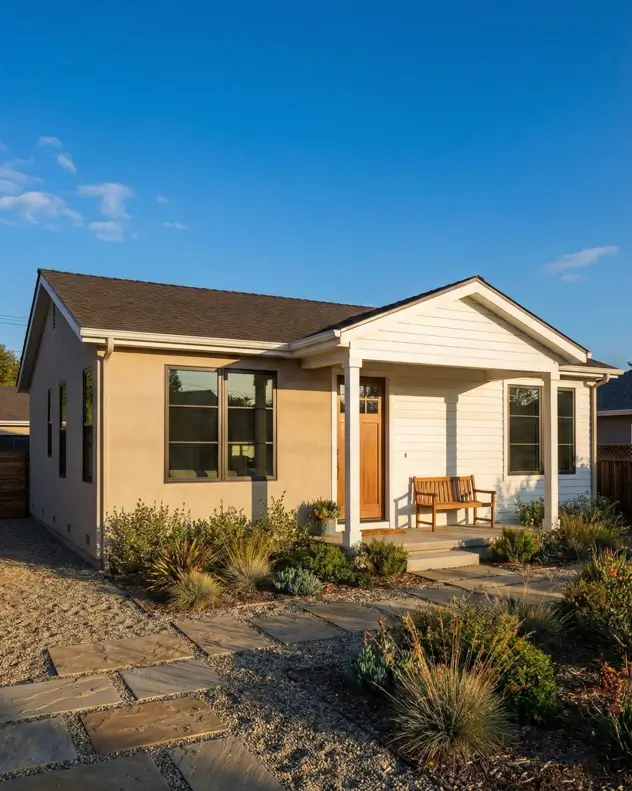 26 Small Ranch-Style House Ideas for Timeless Modern Living 12 Mixed material facade with beige stucco and white siding on a small Ranch house design with a gravel garden.