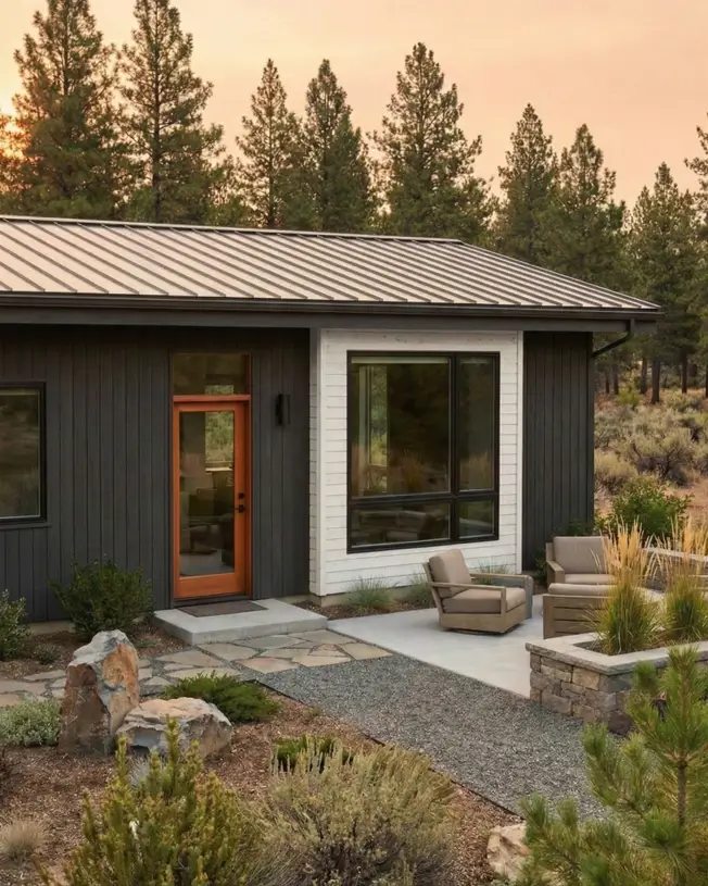 26 Small Ranch-Style House Ideas for Timeless Modern Living 27 Dark charcoal vertical siding with high-contrast white window trim on a modern small Ranch house siding idea.