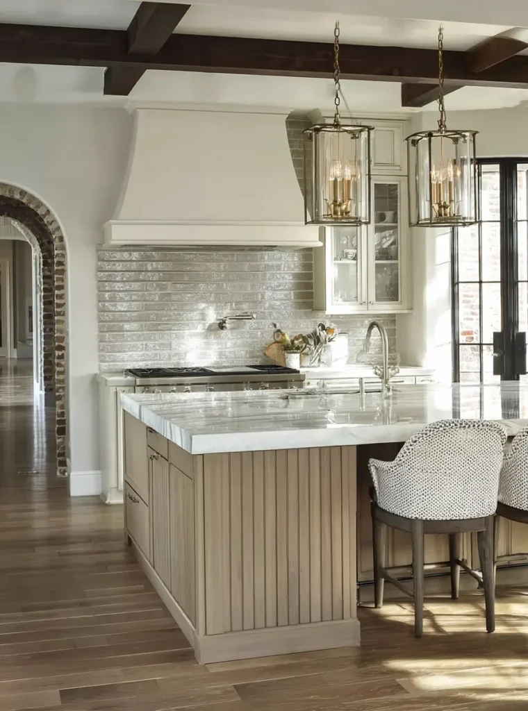 34 Modern Tudor Kitchen Ideas: Old-World Charm, New Appeal 31 Bright kitchen featuring a textured grey tile backsplash, slatted wood island, and large glass lantern pendants.
