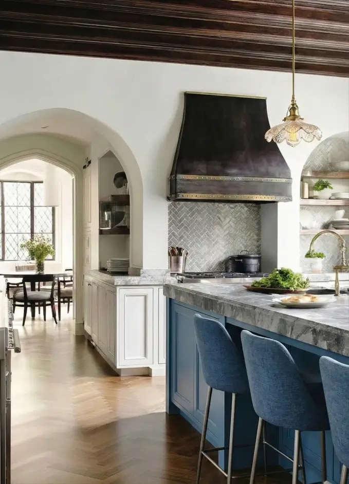 34 Modern Tudor Kitchen Ideas: Old-World Charm, New Appeal 5 Spacious kitchen featuring diamond-pane windows, dark ceiling beams, and a large contrasting island with marble countertops.