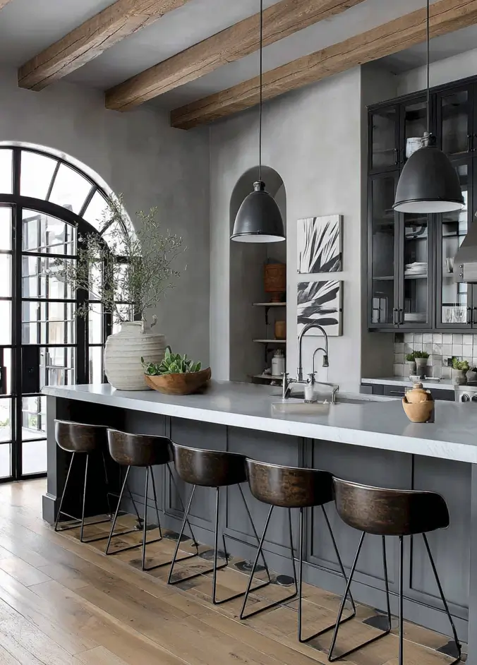 34 Modern Tudor Kitchen Ideas: Old-World Charm, New Appeal 33 Grey kitchen featuring large black arched steel doors, concrete countertops, bronze bucket stools, and rustic ceiling beams.