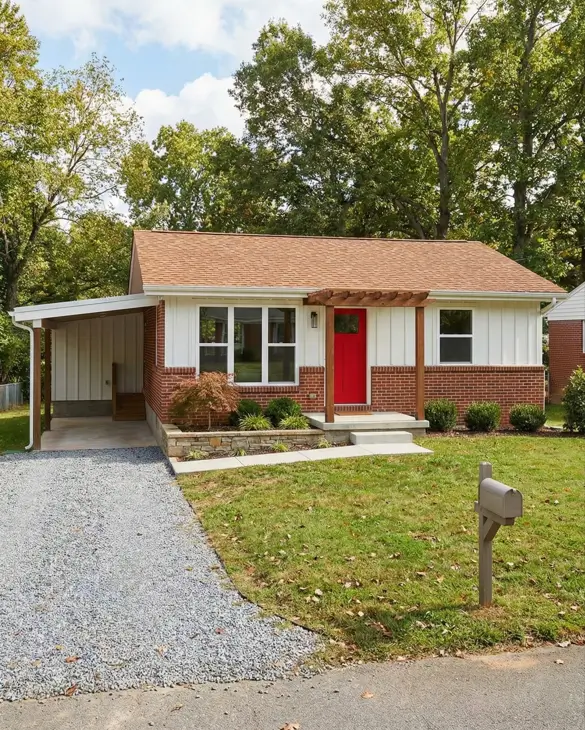 26 Small Ranch-Style House Ideas for Timeless Modern Living 6 Red brick base and white vertical siding on a small Ranch house exterior featuring a red door and pergola.