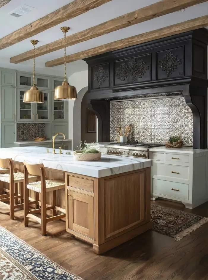 34 Modern Tudor Kitchen Ideas: Old-World Charm, New Appeal 7 Kitchen featuring a large dark carved wood range hood, patterned tile backsplash, and brass pendant lights over a marble island.