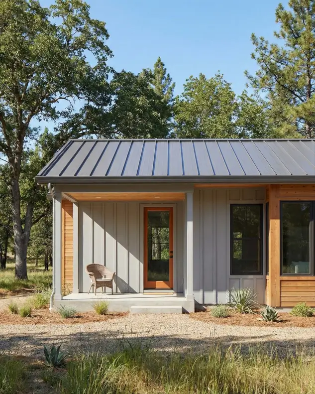 26 Small Ranch-Style House Ideas for Timeless Modern Living 11 Grey vertical siding with natural wood corner accents on a small Ranch-style house featuring a glass entry door.