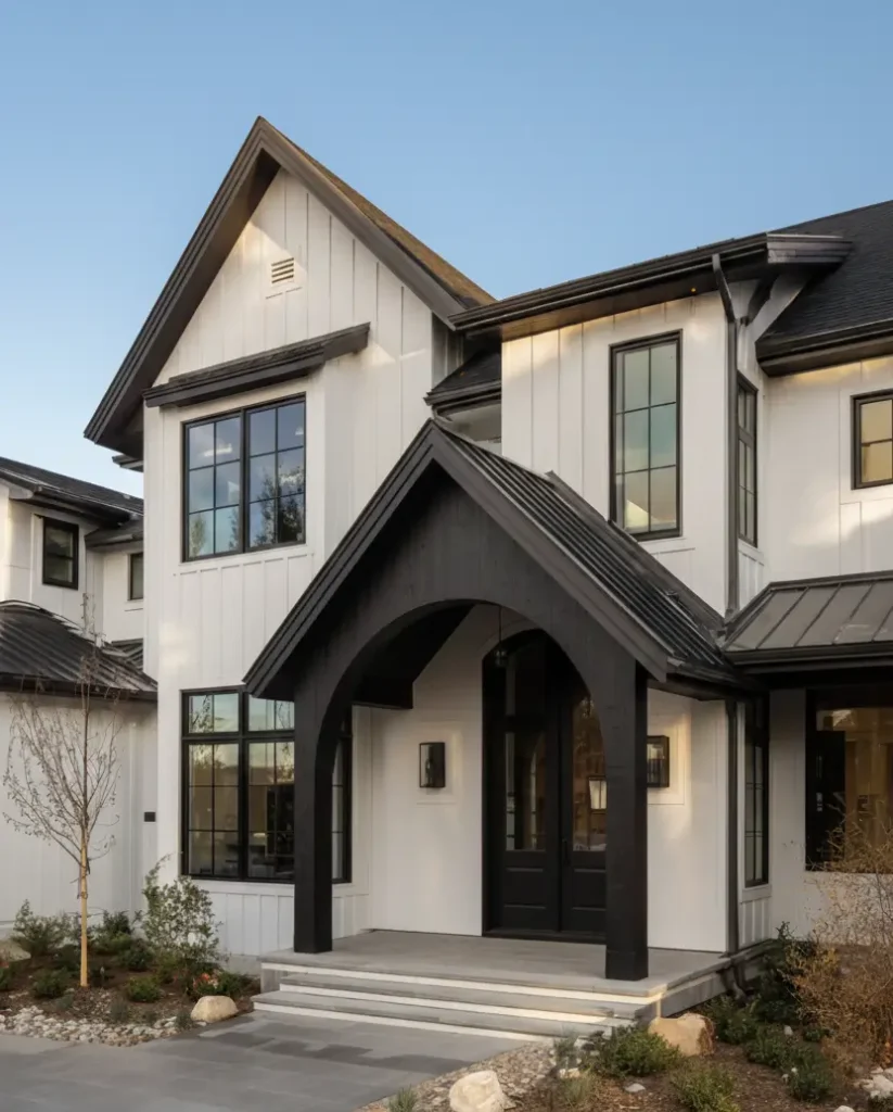 White Farmhouse With Black Trim: 34 Ideas for a Timeless Exterior 5 Bold black arched portico defining the entrance of a white house with black trim under a metal roof.