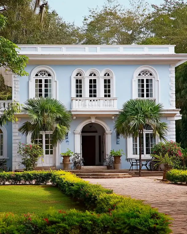 45 Colonial House Design Ideas for a Timeless Exterior 39 Tropical Colonial home with powder blue stucco walls, white quoins, arched fanlight windows, and palm trees