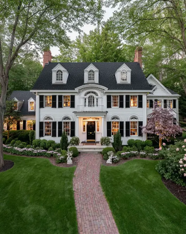 45 Colonial House Design Ideas for a Timeless Exterior 6 Estate Colonial home with white siding, black shutters, arched windows, twin brick chimneys, and brick path