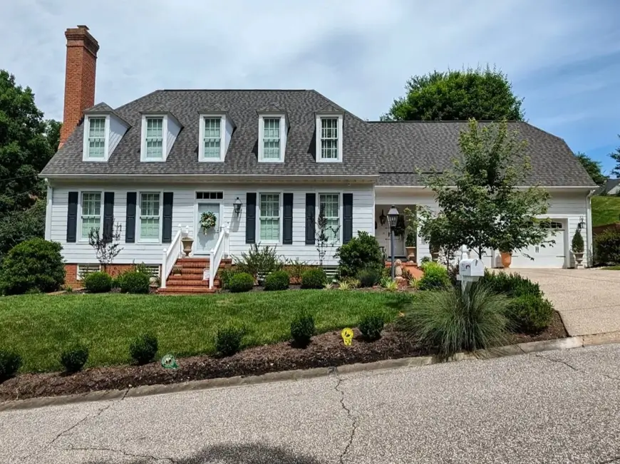 27 Cape Cod Style House Ideas for a Timeless New England Exterior 3 White Cape Cod house with five gabled dormers, black shutters, brick chimney, and an attached garage wing