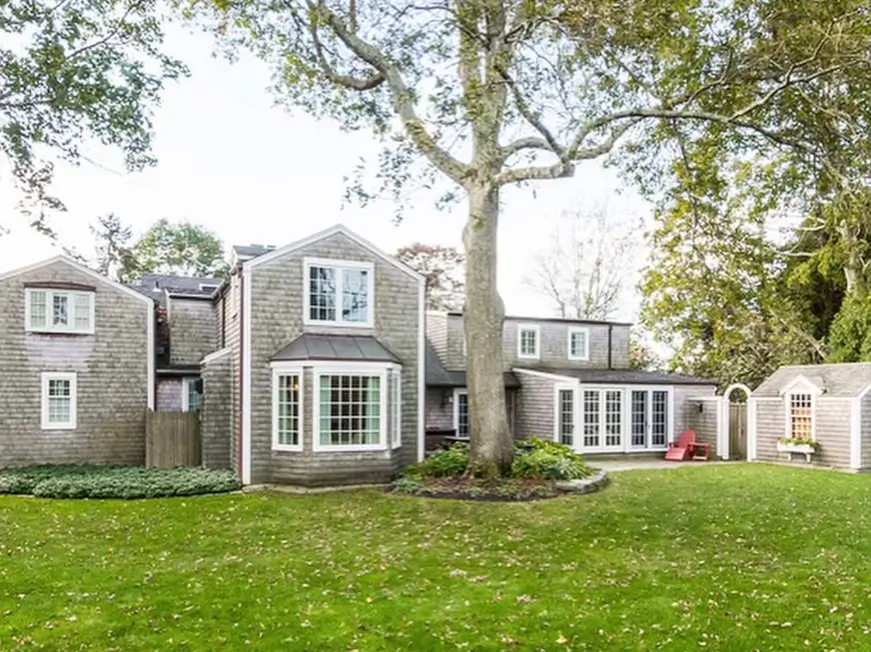 27 Cape Cod Style House Ideas for a Timeless New England Exterior 5 Gray-shingled Cape Cod home with bay window, French doors, multiple gables, and a small garden shed