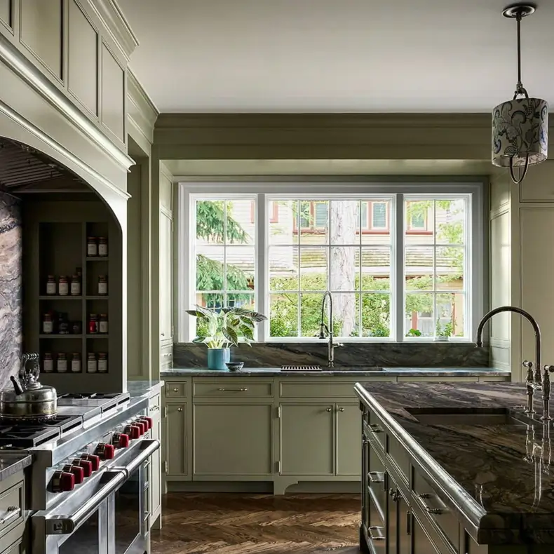 Colonial Interior Design Style: American vs. British (33 Real-Home Ideas) 17 Sage green American Colonial kitchen with raised-panel cabinets, multi-pane windows, and herringbone wood floor