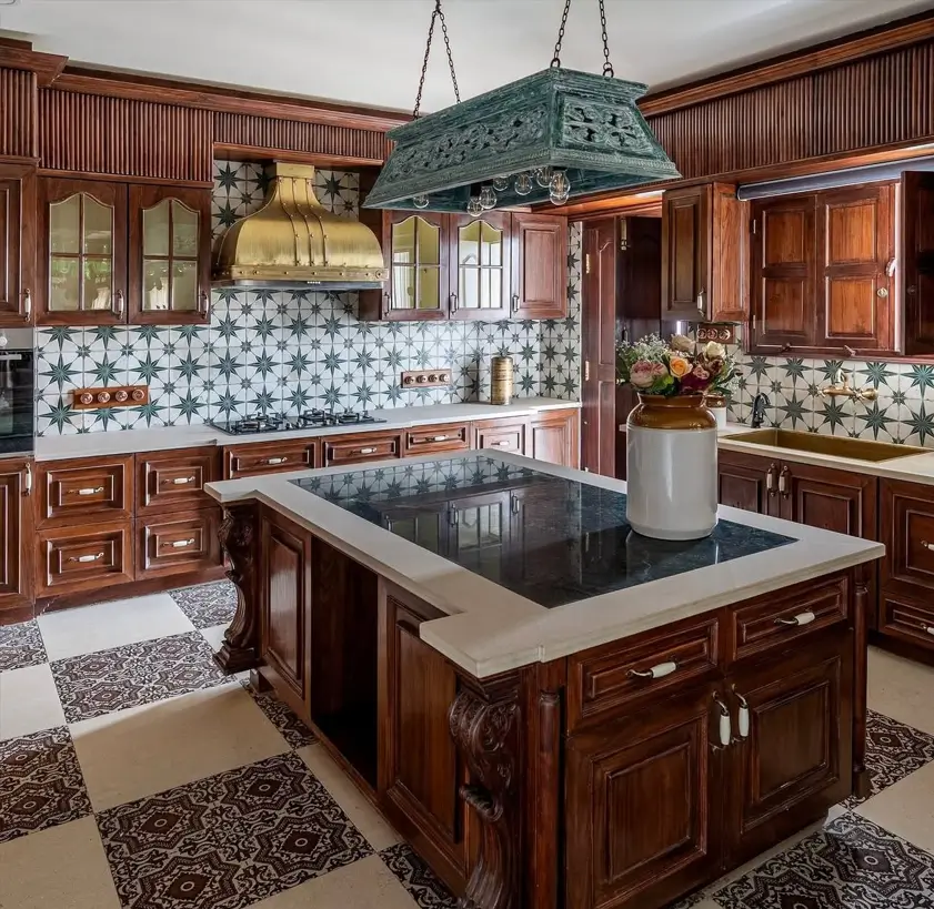 Colonial Style Kitchen: 26 Timeless Ideas, Cabinets & Designs 4 Spanish Colonial kitchen with a carved dark wood island, patterned cement tile, and a brass range hood