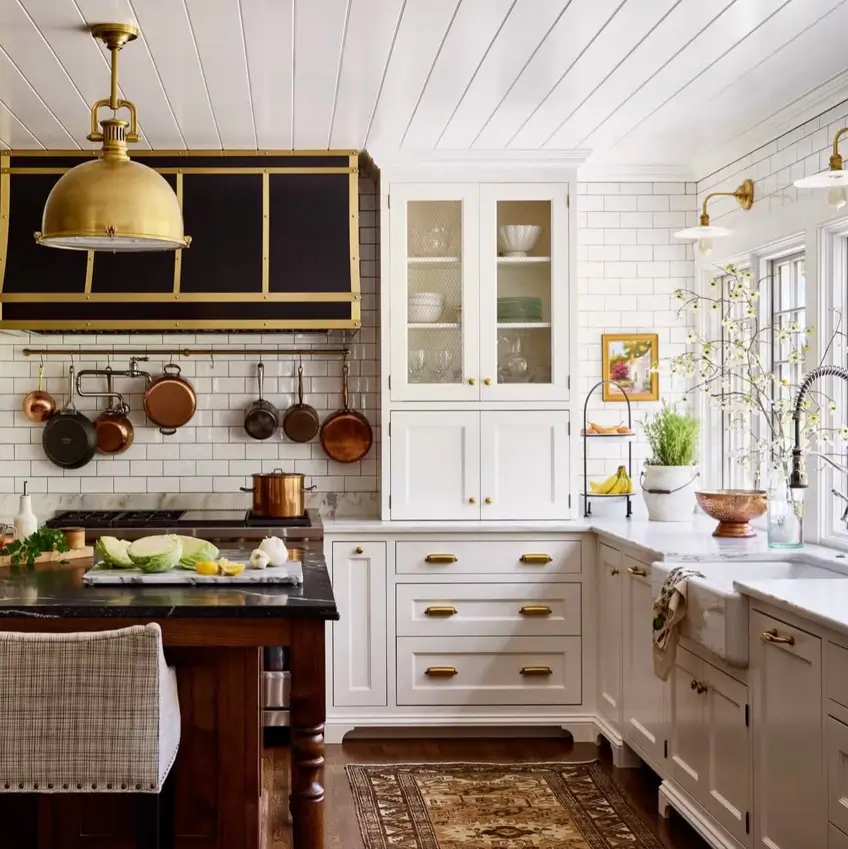 Colonial Interior Design Style: American vs. British (33 Real-Home Ideas) 22 Colonial style kitchen with white shaker cabinets, brass cup pulls, glass-front hutch cabinet, and copper pots