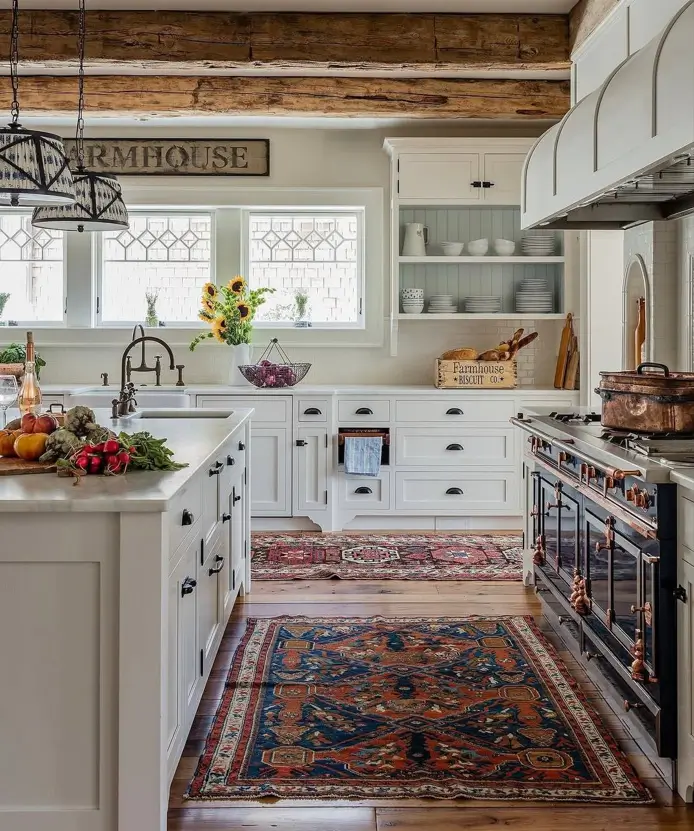 Farmhouse Kitchen Design Ideas: 36 Ways to Get the Look 3 White farmhouse kitchen with layered antique rugs, reclaimed wood beams, and a blue-and-copper range