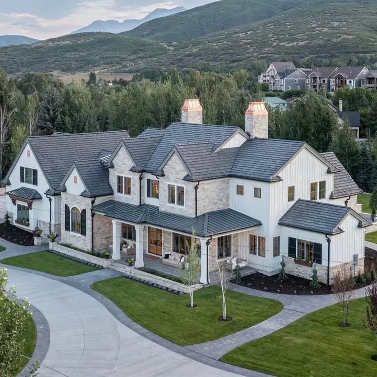 White Farmhouse with Stone Exterior: 29 Ideas That Feel Warm, Not Cold 13 Aerial view of a white farmhouse with stone exterior lower story, twin stone chimneys, and board and batten siding
