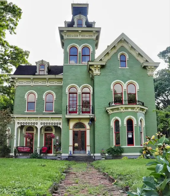 Italianate Style House: 33 Ideas and the Details That Give One Away 18 Green brick Italianate style house with paired arched windows, a corbelled cornice and a mansard-capped tower