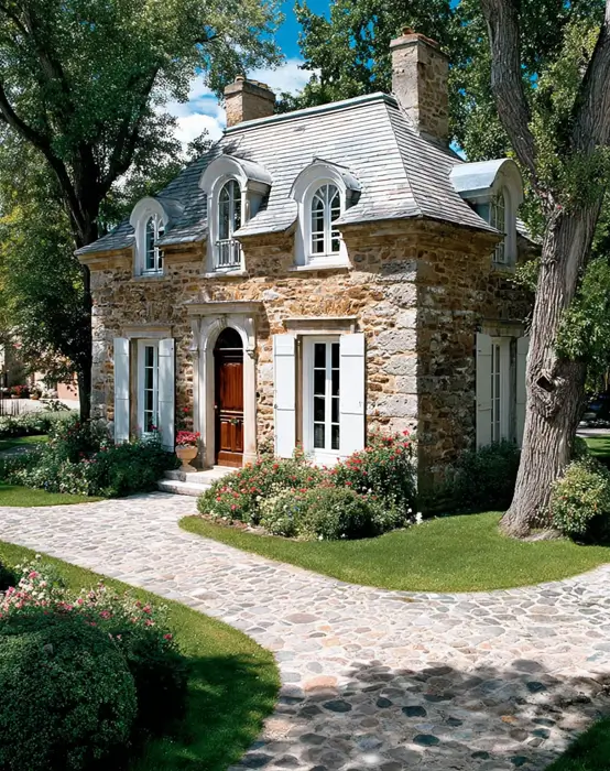 French Country House Style: An Architect's Guide to the Exterior Look 19 French Country House Style stone cottage with curved arched dormers, a mansard roof, and white shutters