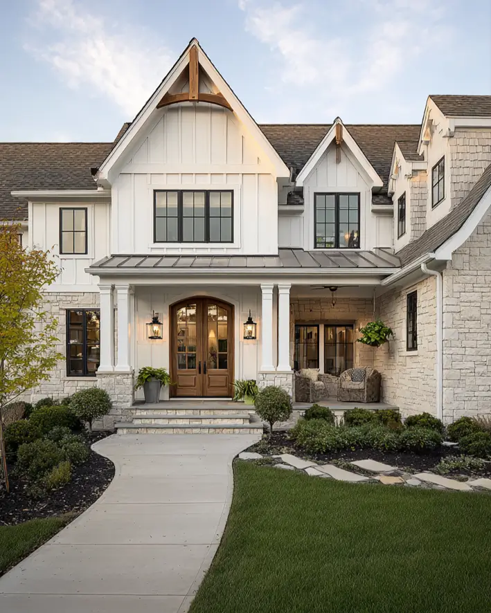 White Farmhouse with Stone Exterior: 29 Ideas That Feel Warm, Not Cold 20 Cream stone wings flanking the board and batten entry gable of a white farmhouse
