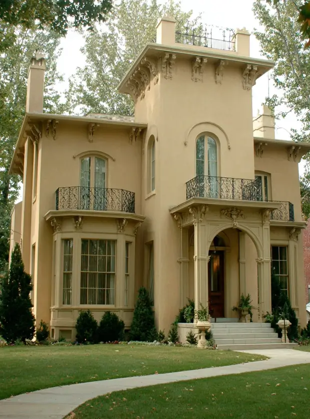 Italianate Style House: 33 Ideas and the Details That Give One Away 22 Buff stucco Italianate style house with scrolled corbels, tall round-headed windows and slim iron balconies