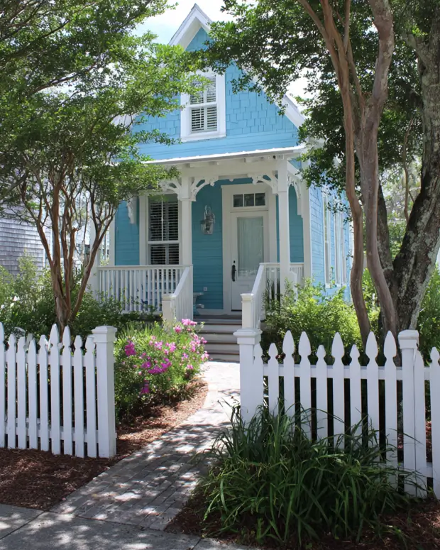 33 Blue and White Cottage Ideas That Always Feel Fresh 24 turquoise blue and white cottage exterior with bright blue siding, white porch, white front door, and a white picket fence