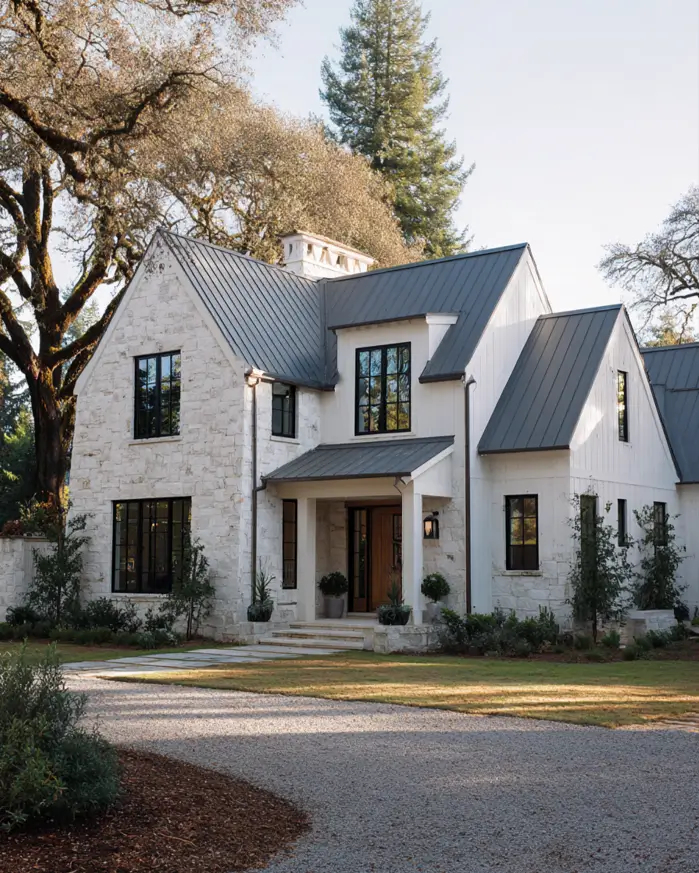 White Farmhouse with Stone Exterior: 29 Ideas That Feel Warm, Not Cold 26 Limewashed stone gable wing with worn patina under a charcoal metal roof