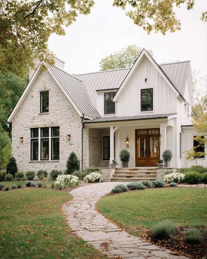White Farmhouse with Stone Exterior: 29 Ideas That Feel Warm, Not Cold 27 Stone farmhouse gable wing with white window trim and a greige metal roof