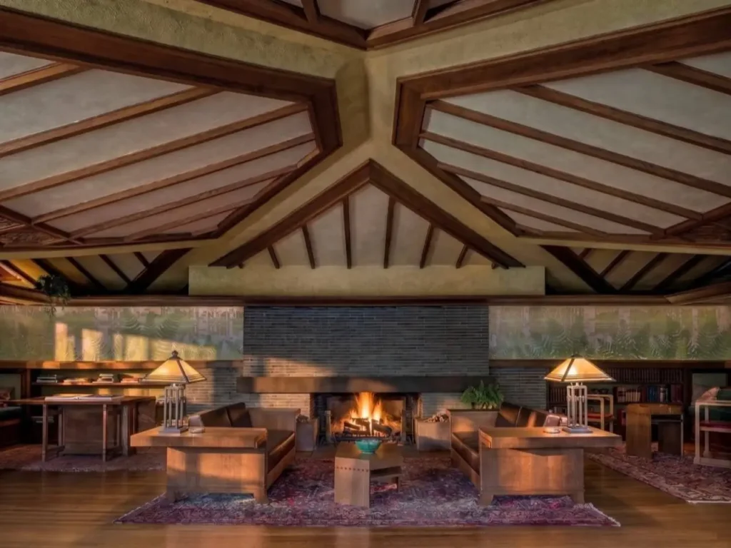 Prairie House Style: Key Features, History, and What Makes These Homes So Timeless 30 Central Roman brick fireplace and oak ceiling ribs in a Prairie style living room with mural frieze