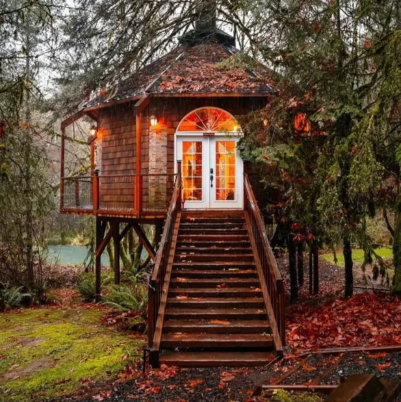 55 Treehouse Design Ideas, From Backyard Platforms to Canopy Cabins 32 Treehouse design ideas with an octagonal cedar shingle cabin on posts, arched glass doors and a long timber stair