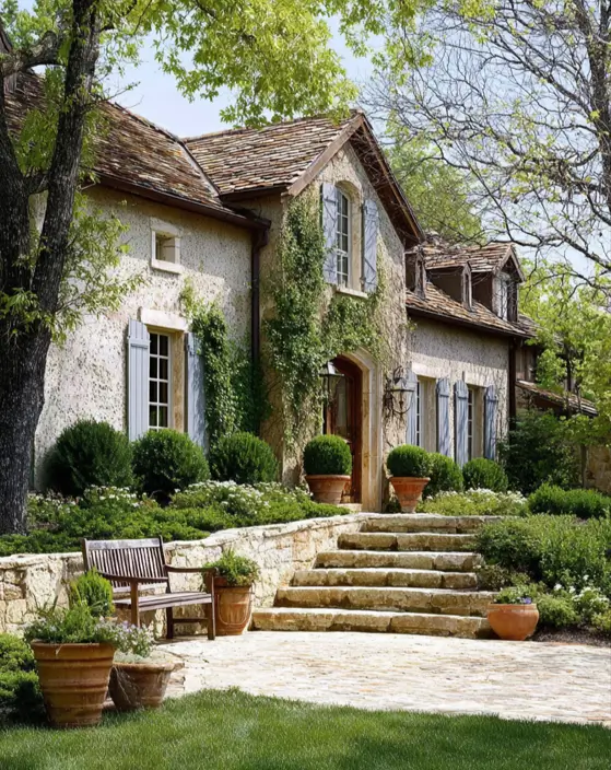 French Country House Style: An Architect's Guide to the Exterior Look 39 French Country House Style stone farmhouse with rough stone garden steps, blue-gray shutters, and tile roof