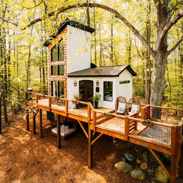 55 Treehouse Design Ideas, From Backyard Platforms to Canopy Cabins 49 Treehouse design ideas with white board and batten cladding, a glazed tower and a long elevated timber walkway deck