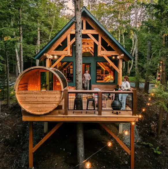 55 Treehouse Design Ideas, From Backyard Platforms to Canopy Cabins 50 Treehouse design ideas with a green timber frame cabin, barrel sauna and string-lit deck raised on braced posts